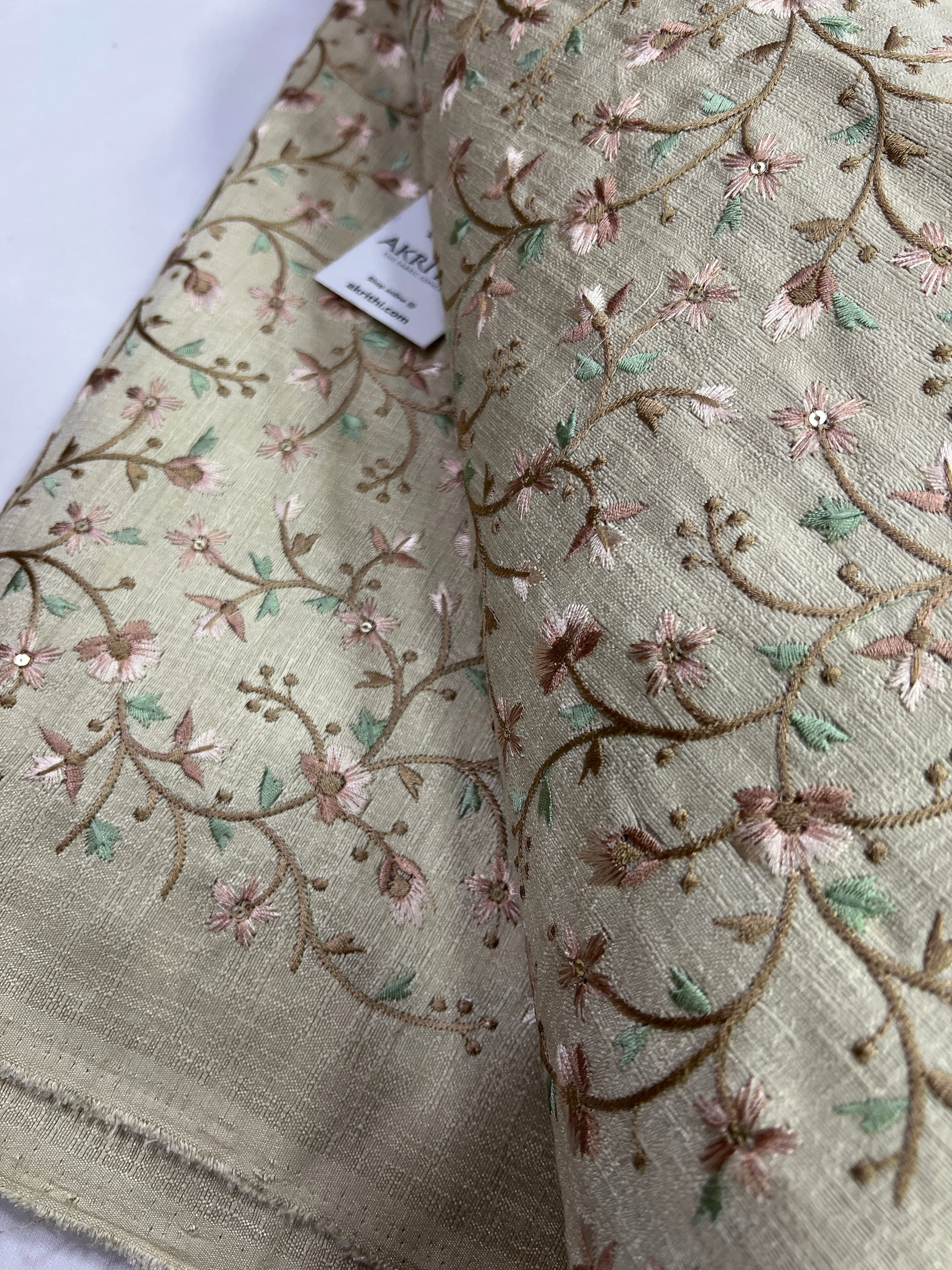 Embroidery on beige raw silk fabric